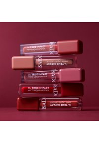 Cinq rouges à lèvres liquides disposés verticalement, présentant un emballage transparent avec des nuances variées de rose et de rouge, des bouchons carrés et un texte en relief.