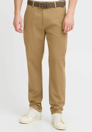 Beige chinos with a straight-leg design, made from cotton fabric. The outfit is complemented by a brown belt and white sneakers.