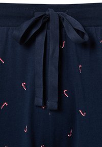 Granatowe szorty piżamowe z gumką ze sznurkiem, ozdobione nadrukiem małych czerwono-białych lasek cukrowych na całej tkaninie. Miękka tekstura.