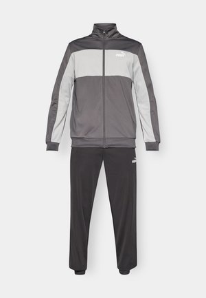 Tepláková súprava obsahujúca zipsovú bundu v tmavosivej farbe so svetlosivými panelmi a zodpovedajúcimi nohavicami. Vyrobená z hladkej látky, obsahuje detail s logom.
