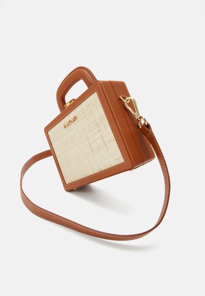 Brown leather handbag with a beige woven front panel, gold hardware, short handle, and a removable shoulder strap. Rectangular shape.