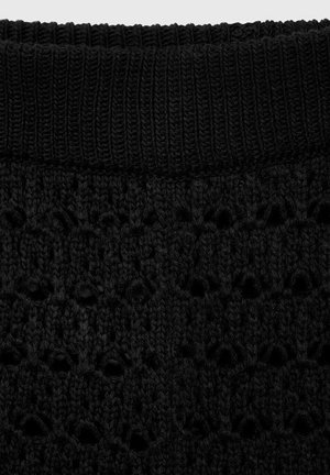 Tissu en tricot noir présentant un motif ajouré et une taille côtelée ajustée. Le matériau semble doux avec une finition texturée.