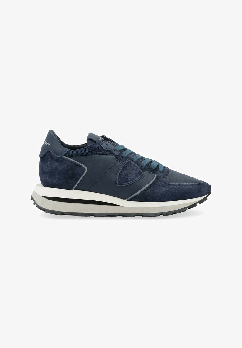Sneakers blu navy con un mix di camoscio e rete. Presentano dettagli testurizzati, lacci piatti e una suola intermedia bianca con una striscia nera.