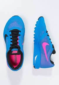 Modré běžecké boty s síťovanou svrchní částí, růžovými akcenty, černými detaily a texturovanou podrážkou. Logo Nike na boku a na jazyku.