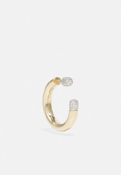 Gold hoop earring featuring two ends; one smooth and polished, the other adorned with small clear crystals for added texture.