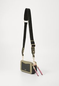 Petite sac bandoulière en cuir olive et noir avec quincaillerie dorée, design texturé, double zip et bandoulière réglable.