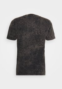 T-shirt noir à manches courtes effet acidulé vu de dos, avec un col rond et une texture subtilement délavée sur toute la surface.