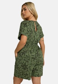 Rompers vert avec un motif floral, à manches courtes, taille élastique et détail en forme de clé à l'arrière. Fabriqué en tissu doux et léger.