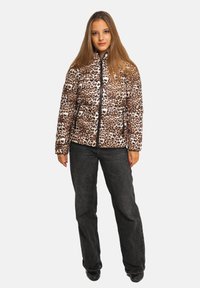 Veste matelassée imprimé léopard avec une finition texturée et rembourrée ; dotée d'un col haut et d'une fermeture éclair devant. Associée à un pantalon en denim foncé.