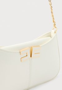 Λευκή δερμάτινη τσάντα με λεία υφή, που διαθέτει χρυσή μεταλλική αλυσίδα ως λουρί και έντονο διπλό λογότυπο "E" στο μπροστινό μέρος.