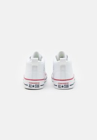Biele kanvasové vysoké tenisky s okrúhlou špičkou, gumovou podrážkou a červenými akcentmi. Na päte a boku je vytlačený nápis "CONVERSE ALL STAR".
