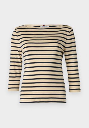 Top de manga larga a rayas en beige y azul marino. Presenta un cuello amplio y un sutil logo de la marca en el pecho. Tejido suave y elástico.