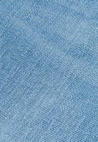 Tejido de mezclilla azul claro con una textura tejida, que presenta ligeras variaciones en el color y pequeñas manchas para un detalle adicional.