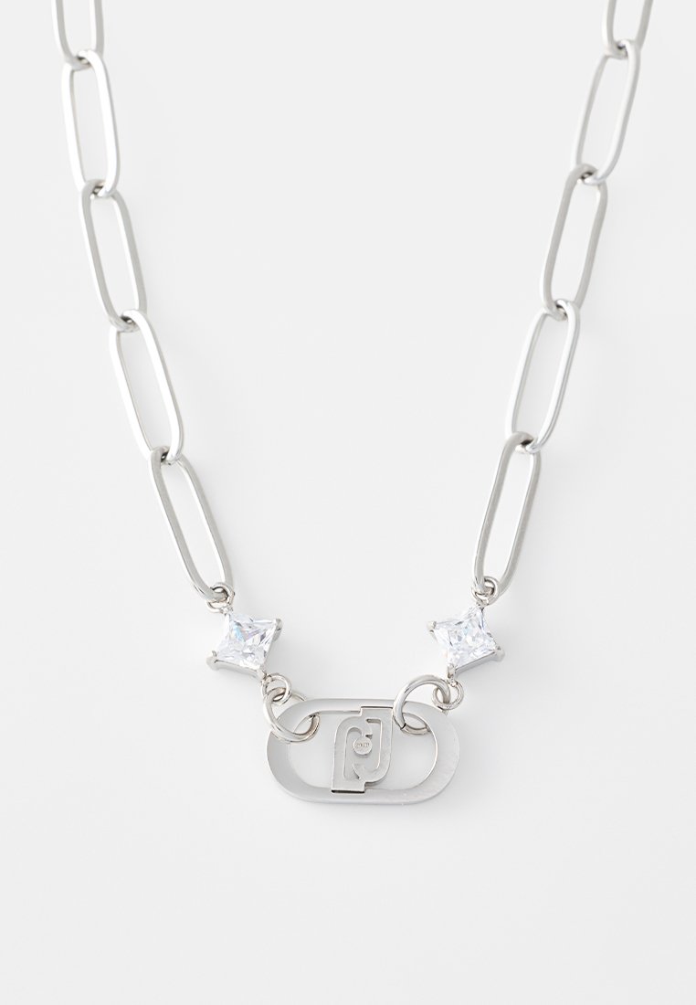 Collier en chaîne argentée avec des maillons allongés, comportant deux cristaux carrés transparents et un maillon ovale central avec un logo gravé.