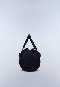 Ronde donkerblauwe duffeltas met zwarte banden en gespen, gezien vanaf het ronde uiteinde tegen een effen lichte achtergrond.