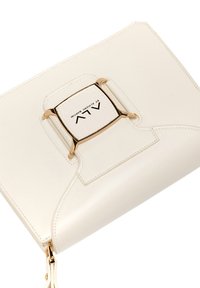 Clutch in pelle bianca con chiusura e logo in tono oro. Presenta una texture liscia e bordi arrotondati, con una chiusura a zip sul fondo.