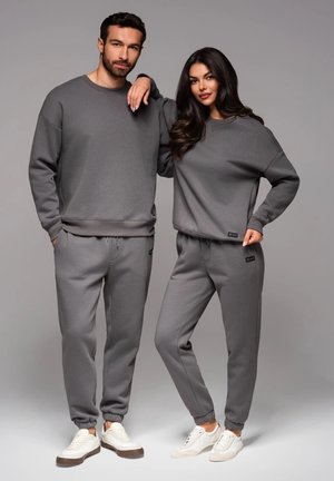 Grijze bijpassende sweatshirts en sweatpants voor mannen en vrouwen, met ribgebreide boorden, een relaxte pasvorm en logodetail aan de uiteinden.