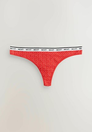 Piros tanga fehér pöttyökkel, fekete-fehér "NEXT" márkanevű derékkal, sima textúrával és minimalista dizájnnal.
