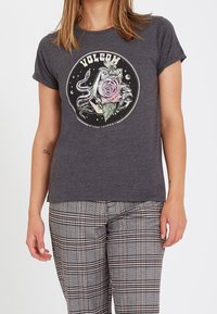 T-shirt gris chiné à manches courtes, avec un graphisme central représentant une rose et un serpent dans un design circulaire ; tissu en mélange de coton.