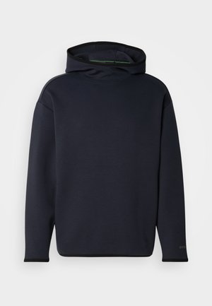 Jūras zils džemperis ar kapuci, izgatavots no mīksta auduma ar brīvu piegriezumu, ar augstu apkakli, garām piedurknēm un diskrētu logotipu uz piedurknes.