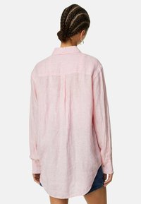 Lichtroze gestreepte blouse met lange mouwen, een ontspannen pasvorm, knoopmanchetten en een gebogen zoom; gemaakt van lichtgewicht stof met een subtiele textuur.