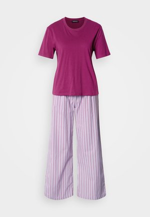 Tricou roz din bumbac cu mâneci scurte, asortat cu pantaloni largi de pijama violet, cu dungi verticale subțiri albe și roșii.
