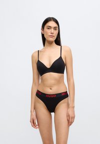 Μαύρο βραλέτο με ρυθμιζόμενες τιράντες και βαθύ ντεκολτέ, σετ με μαύρο εσώρουχο χαμηλής μέσης με κόκκινη μέση "HUGO".