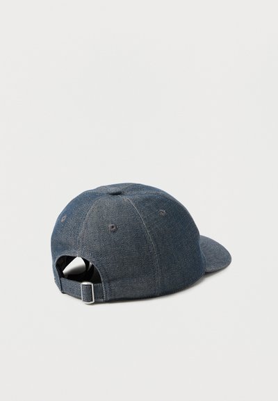 Casquette de baseball en denim bleu foncé avec bride en métal réglable à l'arrière, vue de trois quarts arrière sur un fond uni.