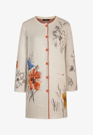 Beige cardigan met lange mouwen, oranje knopen, oranje rand en bloemenprints in oranje, blauw, bruin en geel op de voorkant en mouwen.