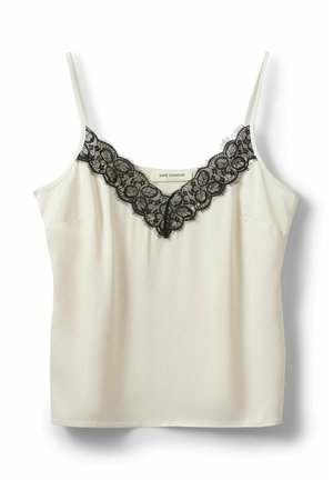 Camisole color crema con spalline sottili e rifinitura in pizzo nero lungo lo scollo a V, etichetta del marchio visibile all'interno del colletto.