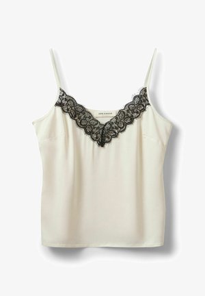 Flødefarvet undertrøje med tynde stropper og sort blondetrim langs V-halsen, mærke synligt inde i kraven.