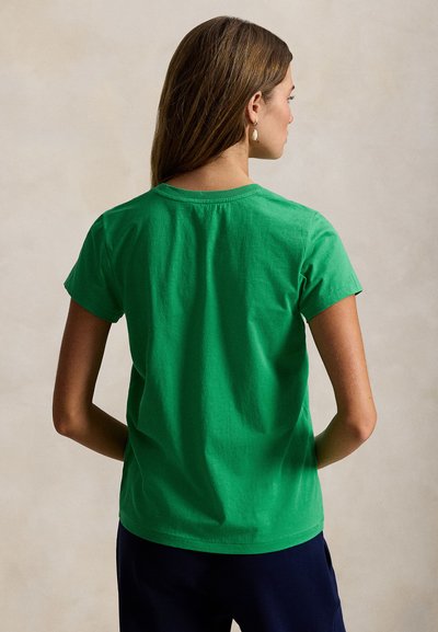 Πράσινο βαμβακερό T-shirt με κοντά μανίκια, στρογγυλή λαιμόκοψη και άνετη εφαρμογή, εμφανιζόμενο από πίσω σε ουδέτερο φόντο.