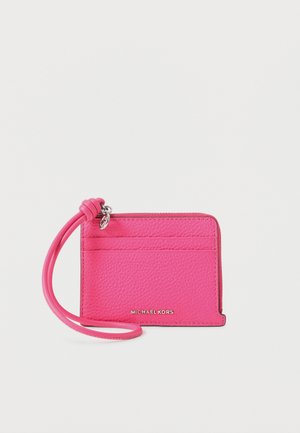 Porte-cartes en cuir rose vif avec bracelet pour poignet, pochette à fermeture éclair et trois emplacements pour cartes, orné d'un petit charm logo en argent.