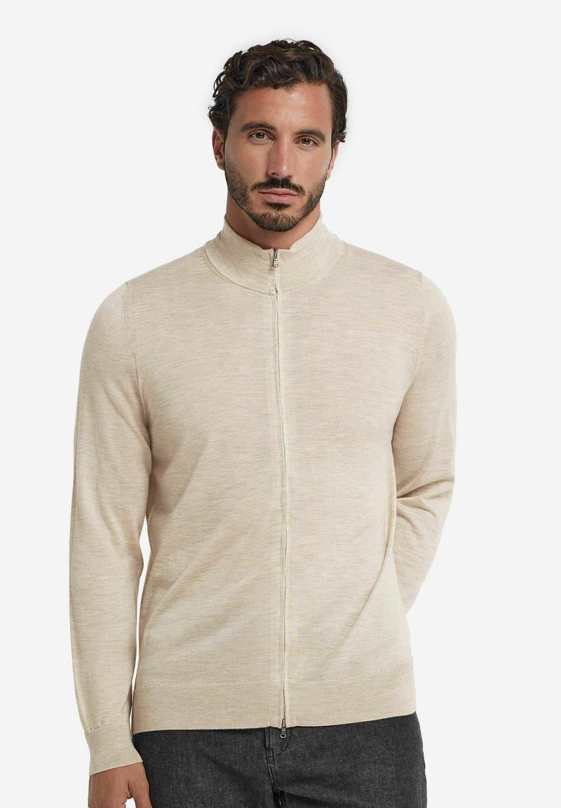 Hellbeige Zip-Up-Pullover mit hohem Kragen, langen Ärmeln und glatter Textur. Hat einen durchgehenden Reißverschluss vorne und einen gerippten Saum.