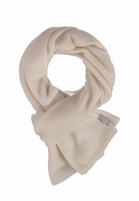 Écharpe en tricot beige clair avec une texture douce, comportant une étiquette dans un coin. Le design est simple et fluide, sans motifs.