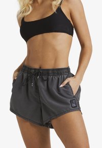 Hallid lühikesed püksid, millel on nööriga vöökoht, küljetaskud ja logoga pehme äär. Valmistatud kergest materjalist, millel on pehme tekstuur.