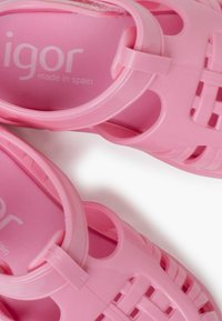 Roze plastic sandalen met een ademend ontwerp, voorzien van uitsparingen en een gestructureerde zool. Binnenin gemarkeerd met "igor made in spain".