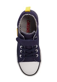 Marineblaue Segelschuhe aus Canvas mit einer weißen Gummikappe, runden Schnürsenkeln, einem Klettverschluss und einer gelben Fersenschlaufe; das Innere hat ein Wabenmuster.