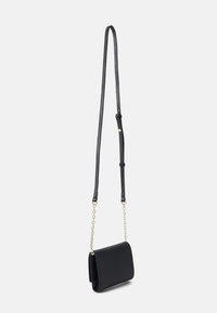 Bolso cruzado de cuero negro con un diseño de solapa, textura suave, correa ajustable y acentos de cadena en tono dorado.