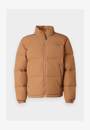 Braune Pufferjacke mit hohem Kragen, vorne mit Reißverschluss und elastischen Bündchen. Verfügt über ein kleines grünes Logo auf der linken Brust. Glatte Textur.