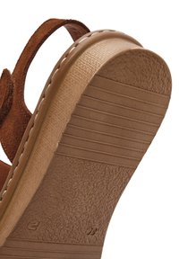 Bruine suede sandaal met een getextureerde buitenzool met horizontale groeven en een gladde rand. Inclusief een bruine leren band.
