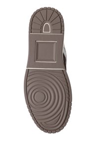 Suola della scarpa in gomma marrone con disegni circolari concentrici, bordi striati e un motivo rettangolare sul tallone. Superficie piatta e testurizzata.