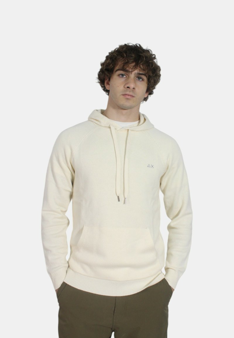 Felpa crema con tasca a canguro, cappuccio con cordino e polsini a costine. Presenta un piccolo logo sul lato sinistro del petto. Tessuto morbido, design casual.