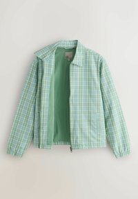Veste zippée à carreaux vert clair et bleu avec col, manches longues et poches latérales, montrée légèrement ouverte pour révéler une doublure intérieure verte unie.