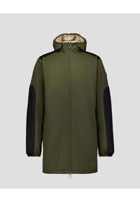 Groene hybride jas met zwarte mouwen, ritssluiting aan de voorkant en capuchon met trekkoord. Gladde textuur met een ademende voering. Voorzien van zijzakken met ritssluiting.