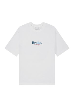 Witte T-shirt met korte mouwen met "Broke." in blauw en "on Sundays" in kleine rode letters, gecentreerd op de borst.