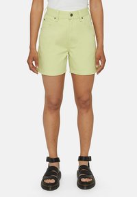 Lys grønn denim shorts med midjehøyde, frontlommer og knappelukking. Kombinert med svarte sandaler med remmer.