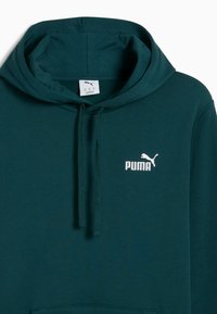Hoodie vert foncé en tissu mélangé coton, avec une poche kangourou, une capuche à cordon de serrage et un logo Puma blanc sur la poitrine.