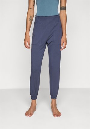 Pantalon de jogging navy en tissu doux, avec une taille élastique, deux poches avant et des poignets ajustés aux chevilles.