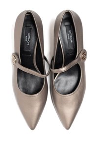 Czółenka z wąskim noskiem, wykonane z metalicznej brązowej skóry z błyszczącym wykończeniem. Posiadają szeroki pasek z okrągłym akcentem. Czarne wnętrze.